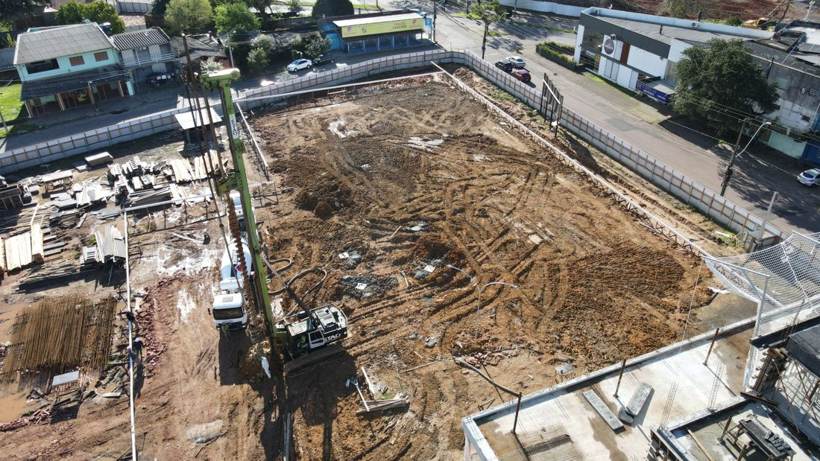 Terreno do novo Hospital DoctorClin no início das fundações, com perfuratriz em operação e a vizinhança ao redor