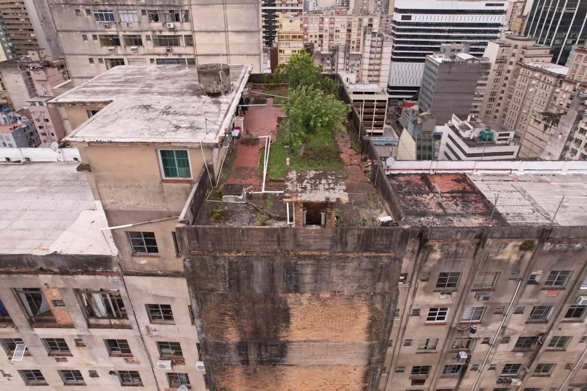 Cobertura de edifício antigo com vegetação crescendo sobre a laje, registrada com drone