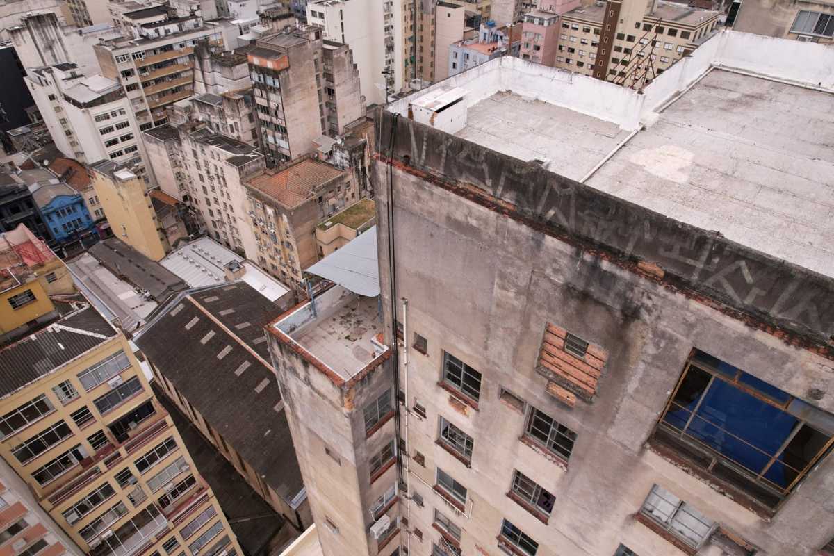 Fachada de edifício com desplacamento e manchas, vista de cima com drone