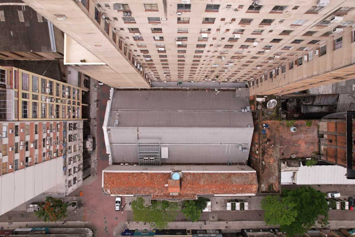 Vista zenital de coberturas e telhado cerâmico entre edifícios altos